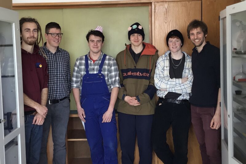 Gruppenbild: Sechs Jungs stehen in einem Raum zwischen zwei Schränken und lachen in die Kamera.